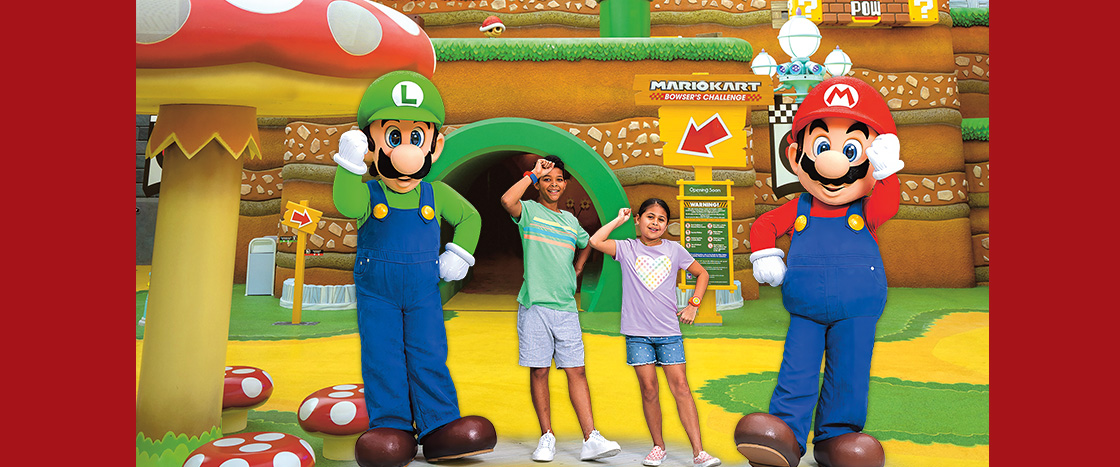 Image of two kids posing with Luigi and Mario in Super Mario world
