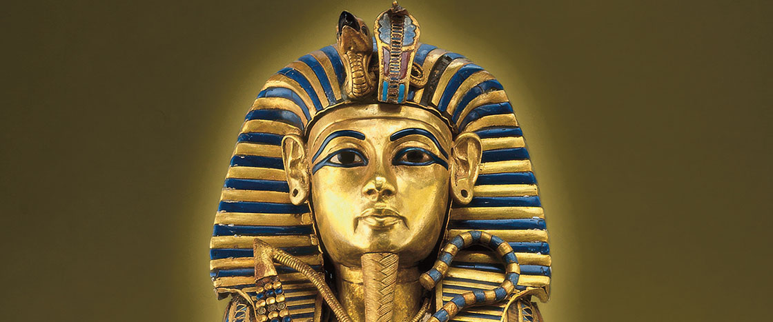The gold and blue funeral mask of Tutankhamun with a striped nemes headdress and cobra